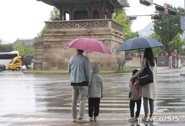 비오는 어린이날인 지난 5일 오전 서울 종로구 경복궁 주변 건널목에 나들이 나온 가족들이 우산을 쓰고 건널목 신호를 기다리고 있다. 2023.05.05.